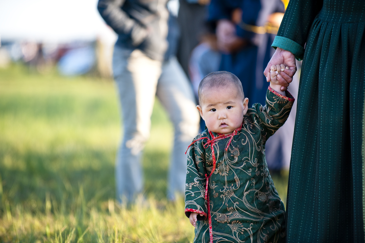 A Mongolian boy holds his grandmother's hand. (Getty Images Bank)