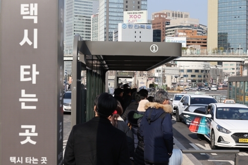 Commuters wait for cabs at a taxi stand in front of Seoul Station on Jan. 14. (Yonhap)