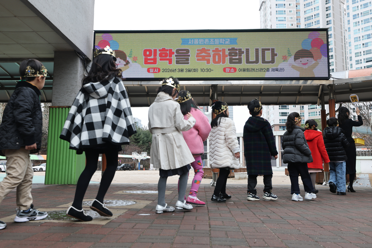 First-graders walk to class with their teachers at an elementary school in Seocho-gu, Seoul, Tuesday. (Yonhap)