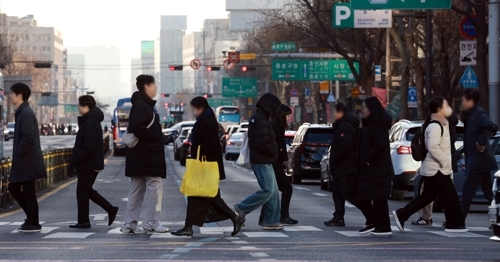 People walk through an intersection in Seoul on Feb. 19. (Yonhap)