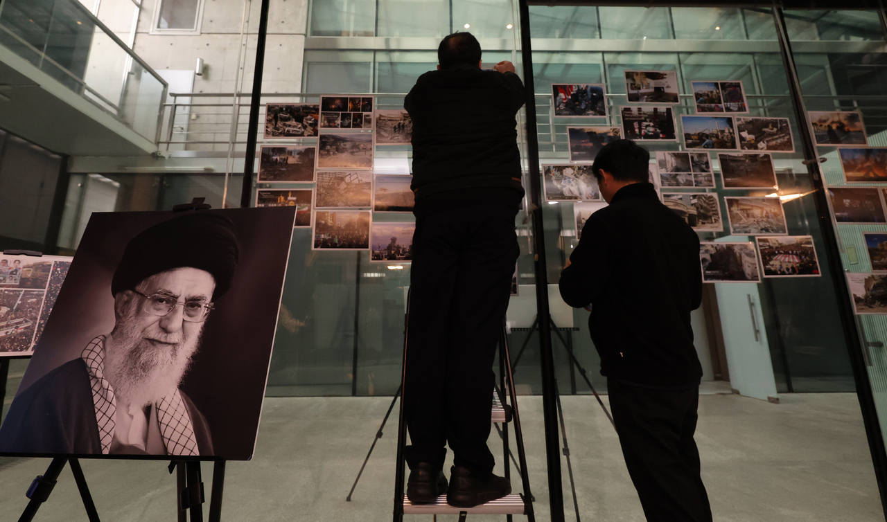 Officials at the Iranian Embassy in Seoul attach photos to a wall ahead of a press conference by Iranian Ambassador to Korea Saeed Koozechi on Thursday. (Yonhap)