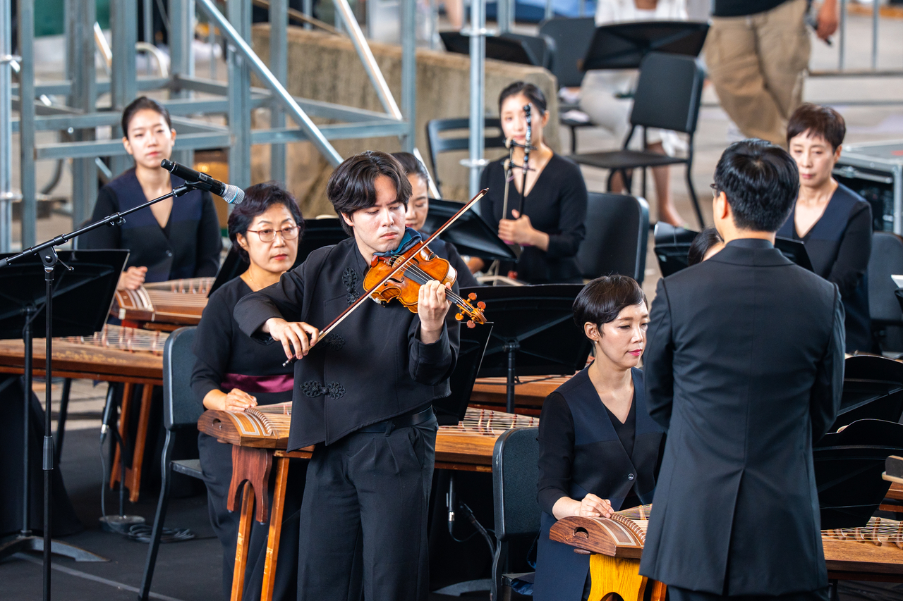 Takashi Lorenz Waschkau performs with the KBS Traditional Music Orchestra in an outdoor performance on June 21 at the National Museum of Korea in Seoul. (KBS Traditional Orchestra)