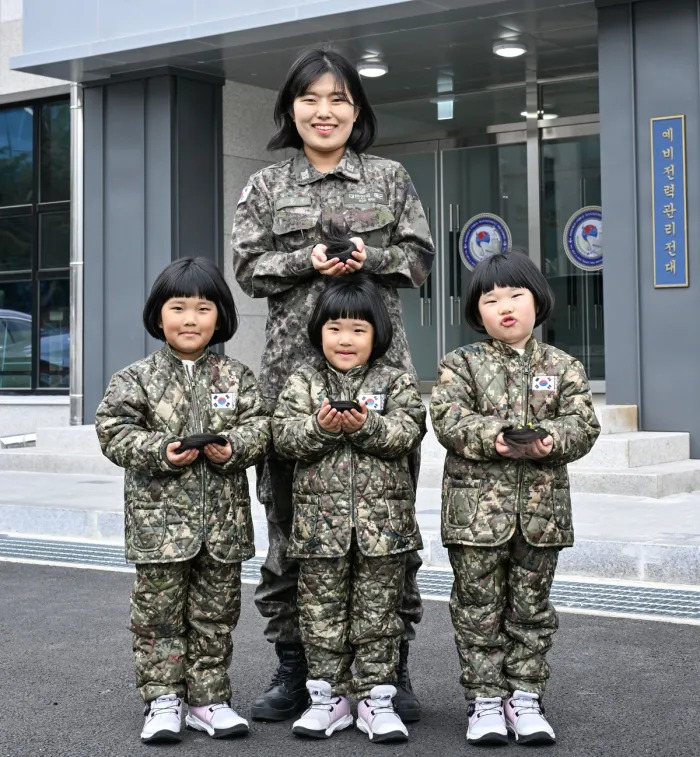 Chief Petty Officer Lee Eun-ju and her triplet daughters hold hair to be donated at a Navy facility in Jinhae, South Gyeongsang Province, Feb. 26. (South Korean Navy)