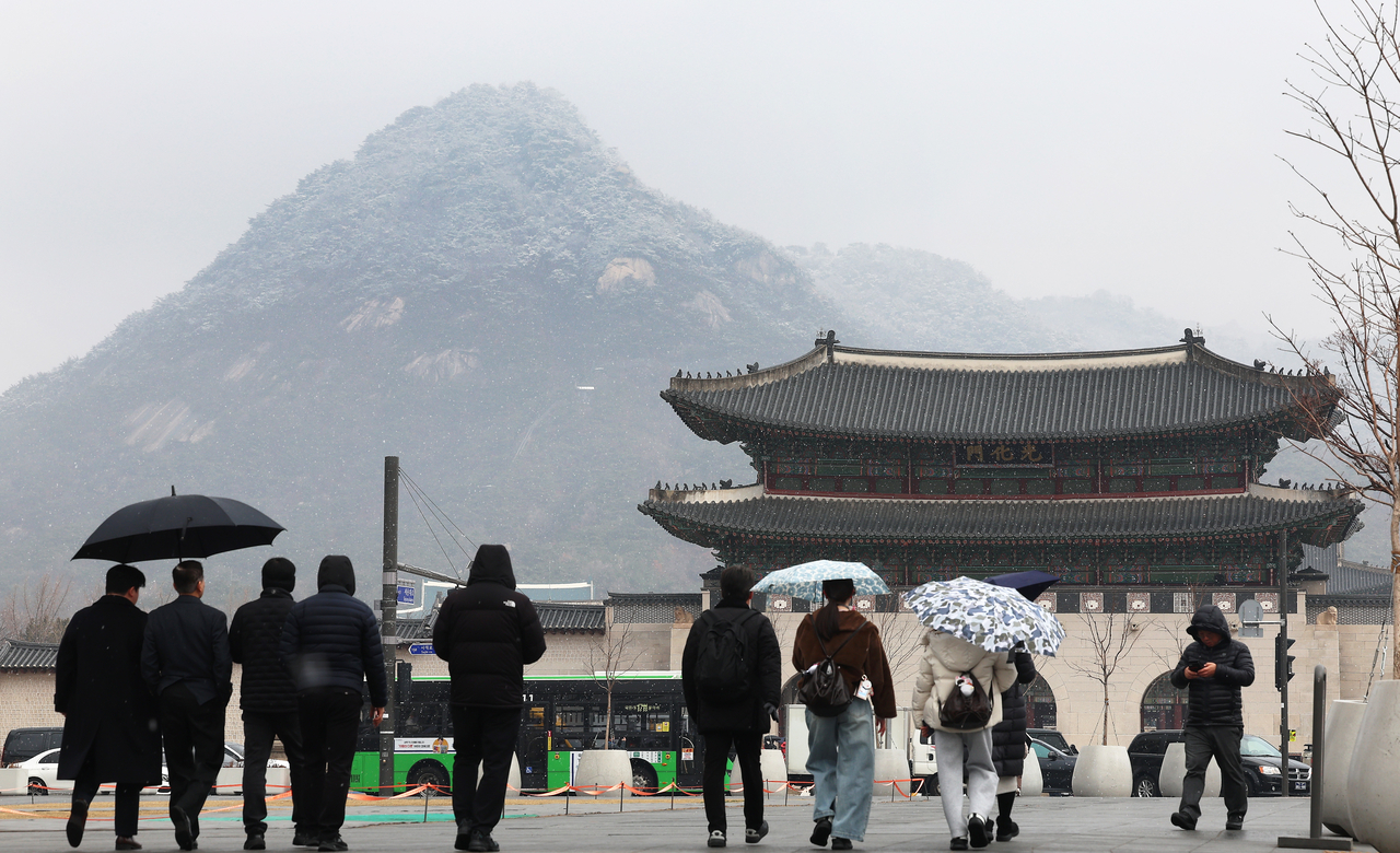 Pedestrians walk through Gwanghwamun Square in Seoul on Friday. (Yonhap)