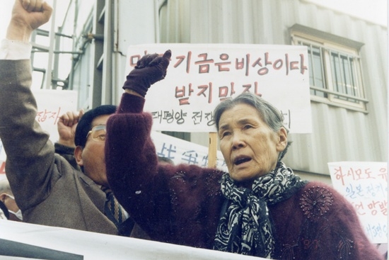Kim Hak-soon (right) protests a plan to compensate victims of Japanese military sexual slavery through a private fund at a rally. (Ahn Hae-ryong)