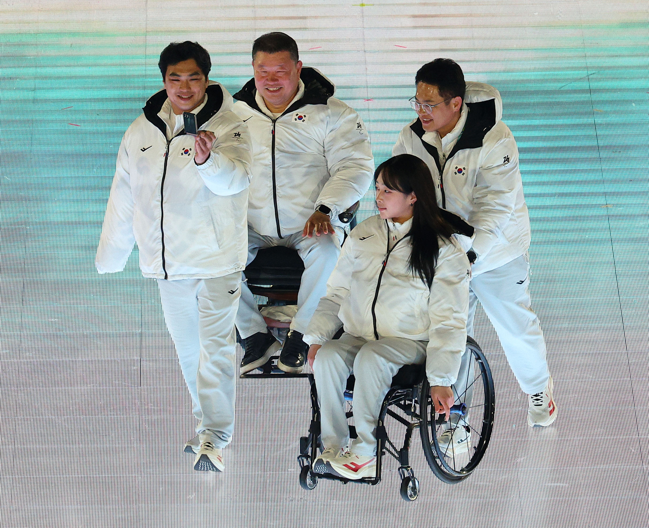 From left: athletes' village chief Jeon Seon-ju, para snowboard athlete Lee Chung-min, para alpine skier Park Chae-yi, and delegation head Yang Oh-yeol of Team Korea enter the opening ceremony for the 2026 Milan Cortina Winter Paralympics at Verona, Italy, on Friday. (Yonhap)