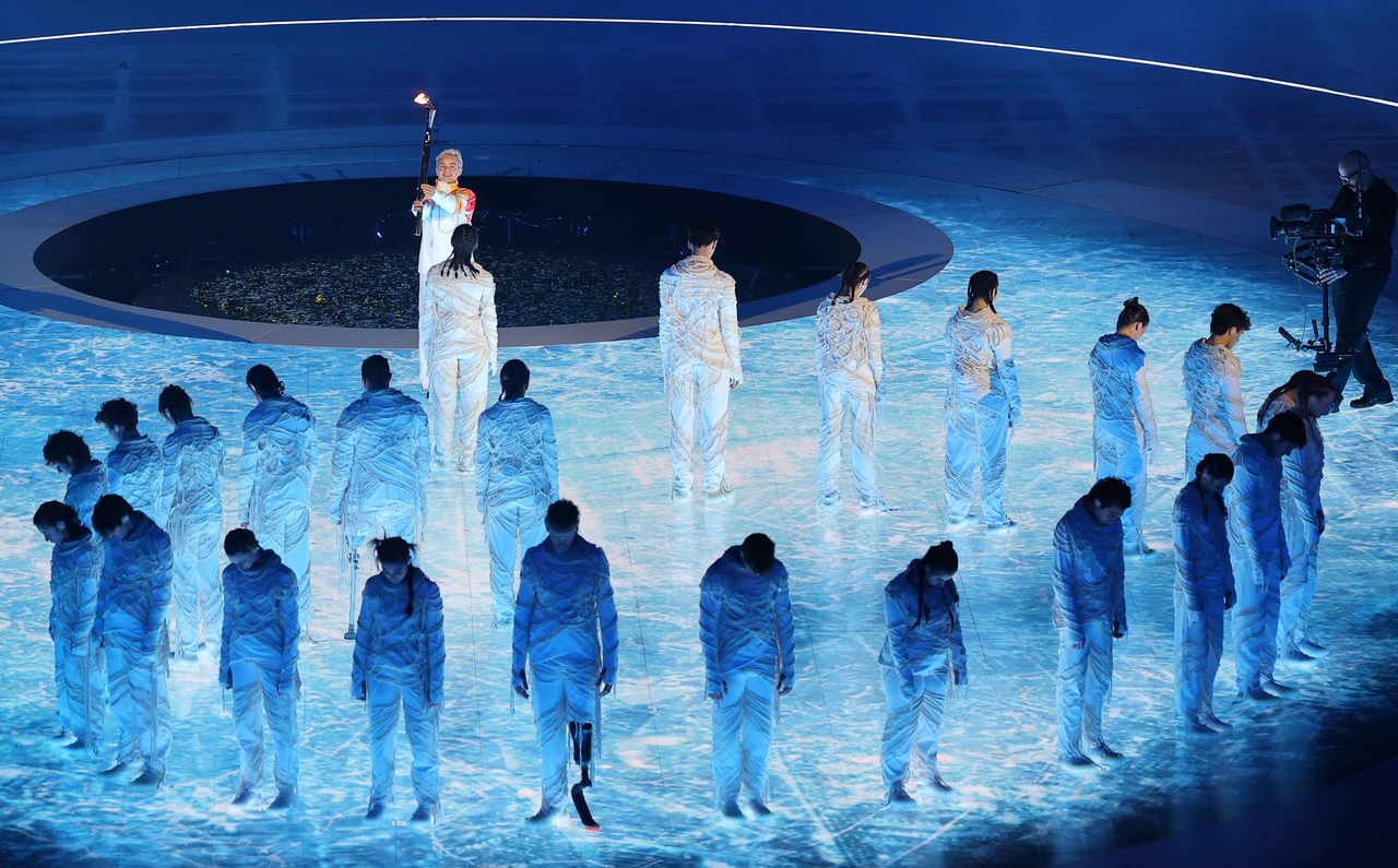 Bebe Vio, a legendary para wheelchair fencer, carries the flame at the opening ceremony of the 2026 Milan Cortina Winter Paralympics held at Verona Arena in Italy on Friday. (Yonhap)