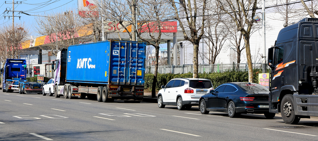 Large trucks and passenger cars line up in front of a gas station in Jung-gu, Incheon, on Saturday, seeking lower fuel prices, as gasoline and diesel prices at domestic gas stations are rising steeply following the impact of US and Israeli airstrikes on Iran. (Yonhap)