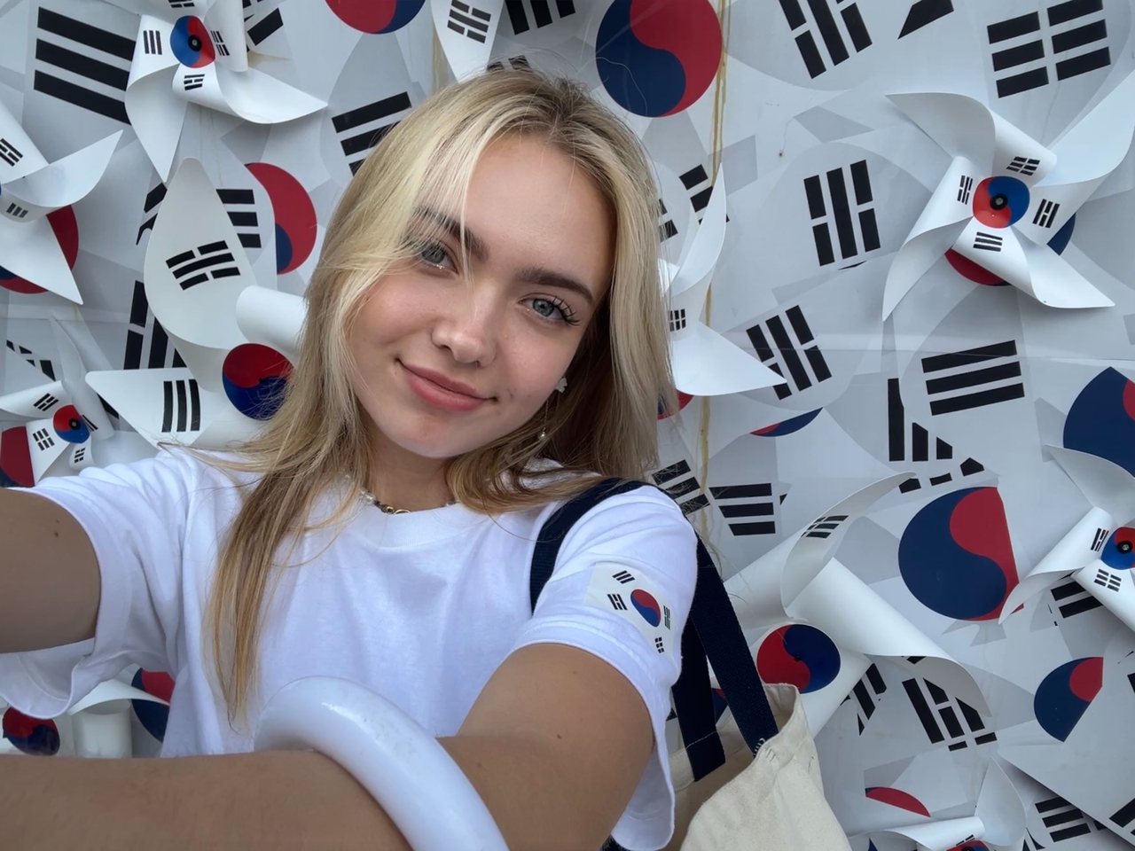 Erica Scorohod takes a selfie in front of a wall covered with South Korean flags. (Erica Scorohod)