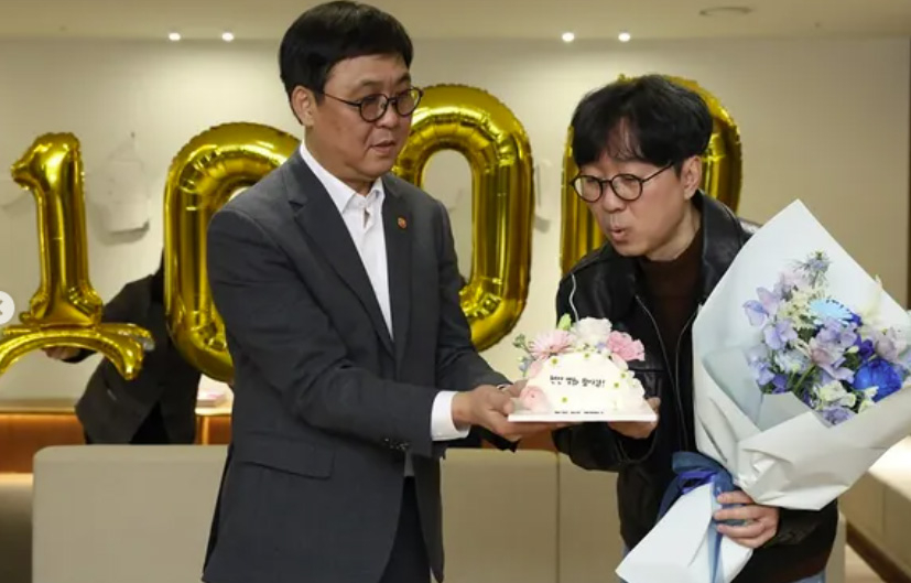 Culture Minister Chae Hwi-young presents director Jang Hang-jun with cake and flowers to celebrate "The King's Warden" crossing 10 million admissions on Friday (Yonhap)