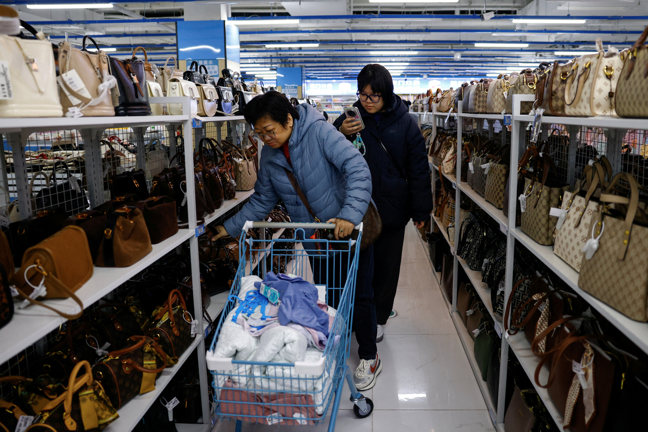 Customers shop for bags at the Wankelai store in Beijing on Feb. 27, 2025.   Reuters-Yonhap