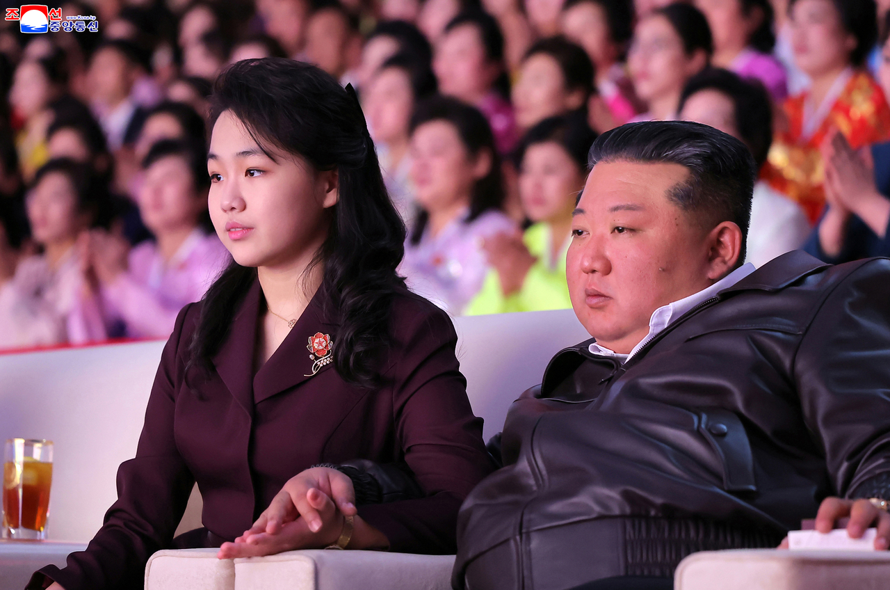 North Korean leader Kim Jong-un (right), seated next to his daughter Ju-ae, watches a performance marking International Women's Day on Sunday at Pyongyang Indoor Stadium, in this photo released the next day by the Korean Central News Agency. (KCNA-Yonhap)