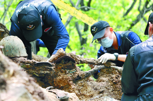 Service members excavate human remains believed to be from soldiers killed during the Korean War at a Defense Ministry recovery site. (Ministry of National Defense)