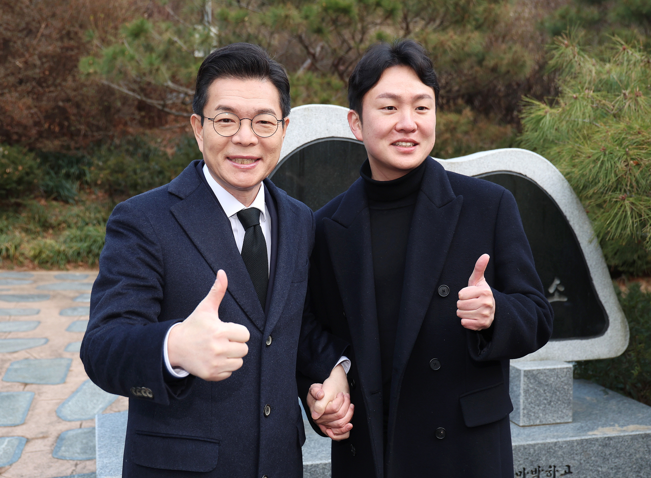 Chong Won-o (left) poses for a photo with a citizen during his visit to Seoul National Cemetery in Seoul on Monday. (Yonhap)