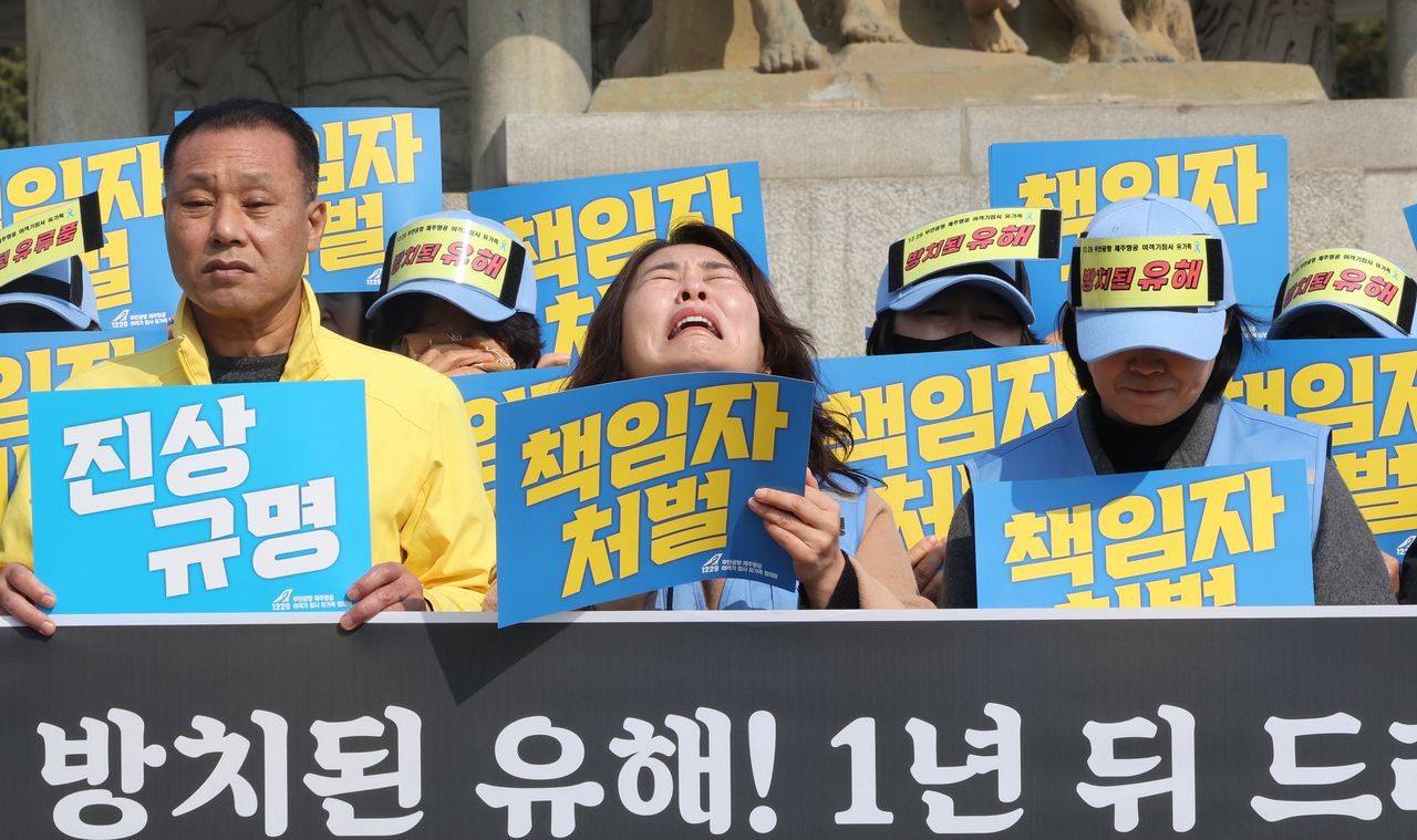 Bereaved families of victims of the 2024 Jeju Air crash protest the investigation and post-accident recovery process on Monday near Cheong Wa Dae in central Seoul. (Yonhap)