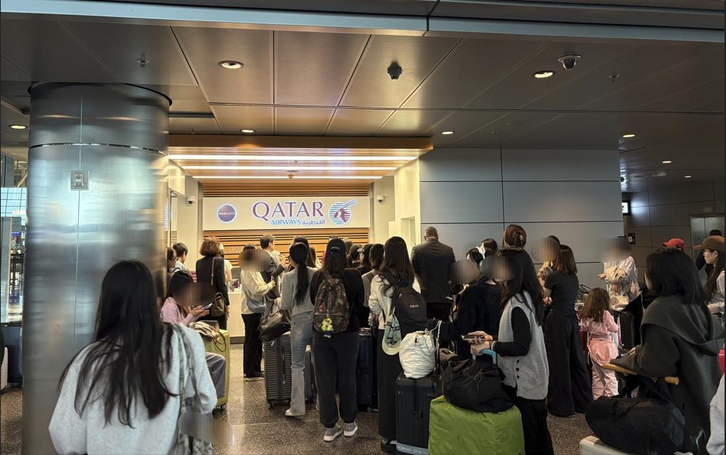 South Korean nationals wait in line to board a special commercial flight arranged by Qatar for their return home on Monday, amid flight disruptions due to the widening conflict in the Middle East, in this photo provided by the foreign ministry. (Yonhap)