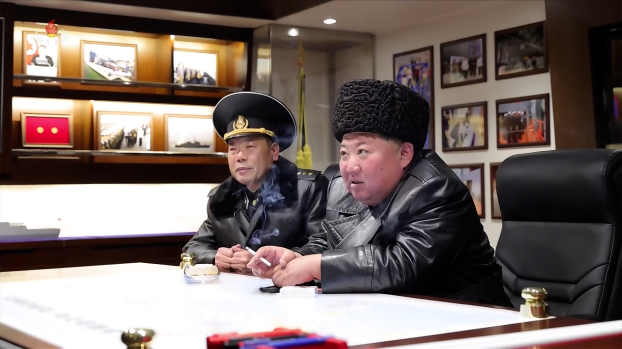 North Korean leader Kim Jong-un, right, inspects training operations aboard what the North claims to be a newly built 5,000-ton destroyer Choe Hyon and observes a test launch of a ship-to-land strategic cruise missile ahead of the vessel’s commissioning on March 3–4, according to Korean Central Television on March 5. Kim is seen sitting with Navy Commander Pak Kwang-sop while smoking in a meeting room aboard the ship. (KCTV-Yonhap)
