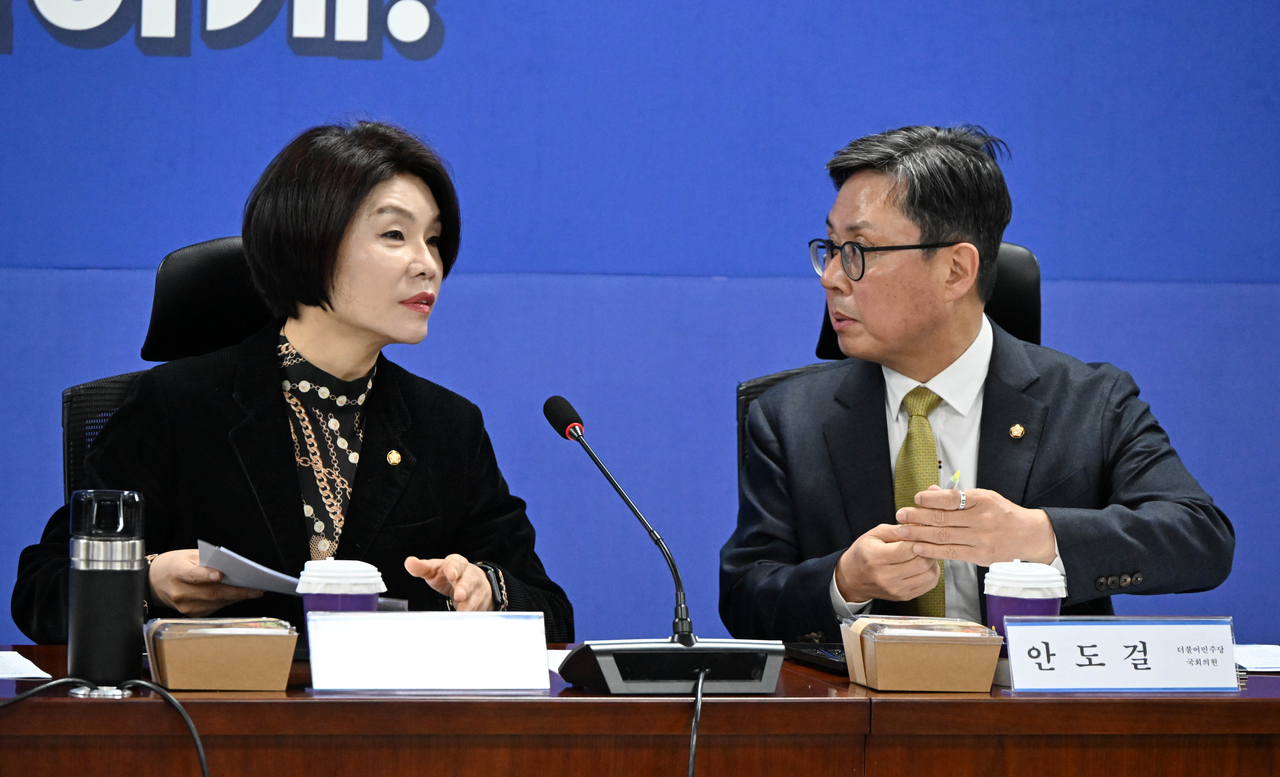 Reps. Han Jeoung-ae (left) and Ahn Do-geol of the Democratic Party of Korea is seen during a meeting with senior government officials in the National Assembly on Tuesday. (Lee Sang-sub/The Korea Herald)