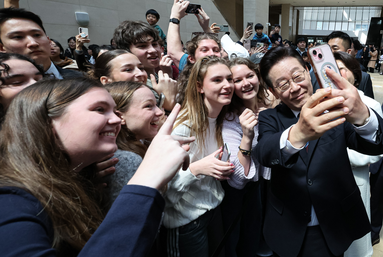 President Lee Jae Myung takes a selfie with foreign visitors at the National Museum of Korea in Seoul on Feb. 26, 2026.  (Yonhap)