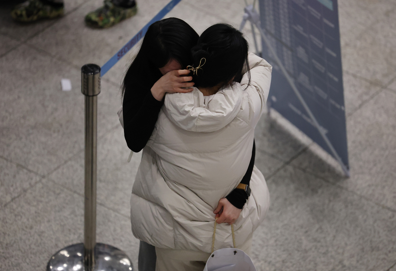 South Koreans who had been staying in the Middle East embrace family members after arriving at Incheon Airport on a chartered flight from Abu Dhabi, United Arab Emirates, Monday. (Yonhap)