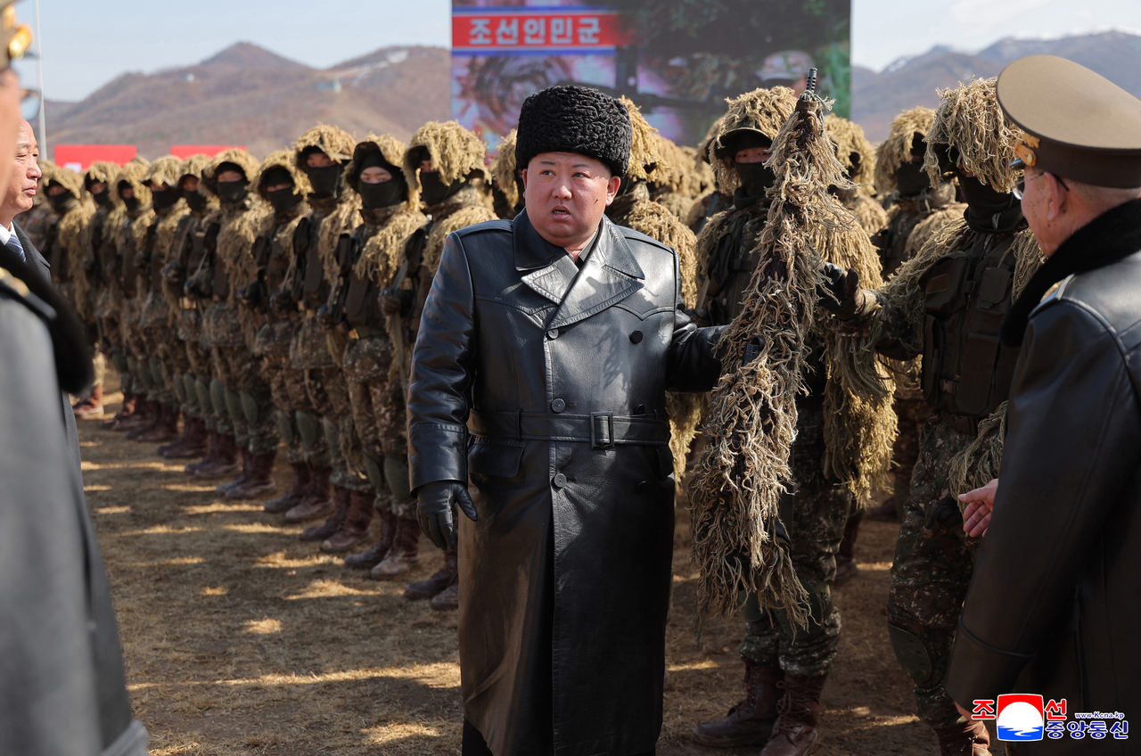 North Korean leader Kim Jong-un (center) meets soldiers dressed in camouflage as he visits a training base of the North Korean army in Pyongyang on March 3, 2026, to oversee a shooting contest of snipers from the army's units at all levels that it held to mark Sniper's Day, in this photo released by North Korea's official Korean Central News Agency on March 5. (Yonhap)
