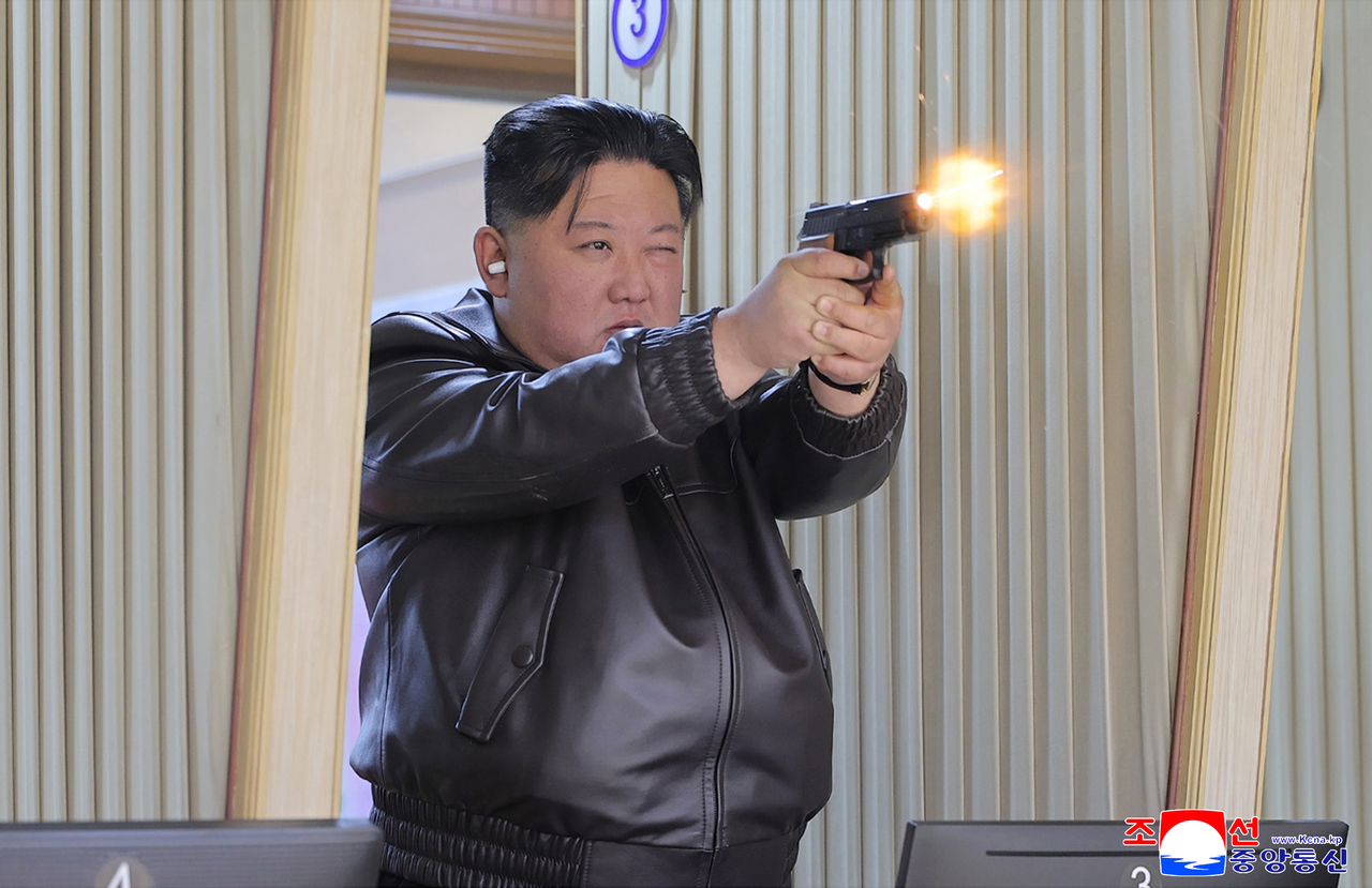 North Korean leader Kim Jong-un fires a pistol at a shooting range as he inspects a weapons factory at an unspecified location on Wednesday in this photo released by North Korea's official Korean Central News Agency the next day.  (Yonhap)