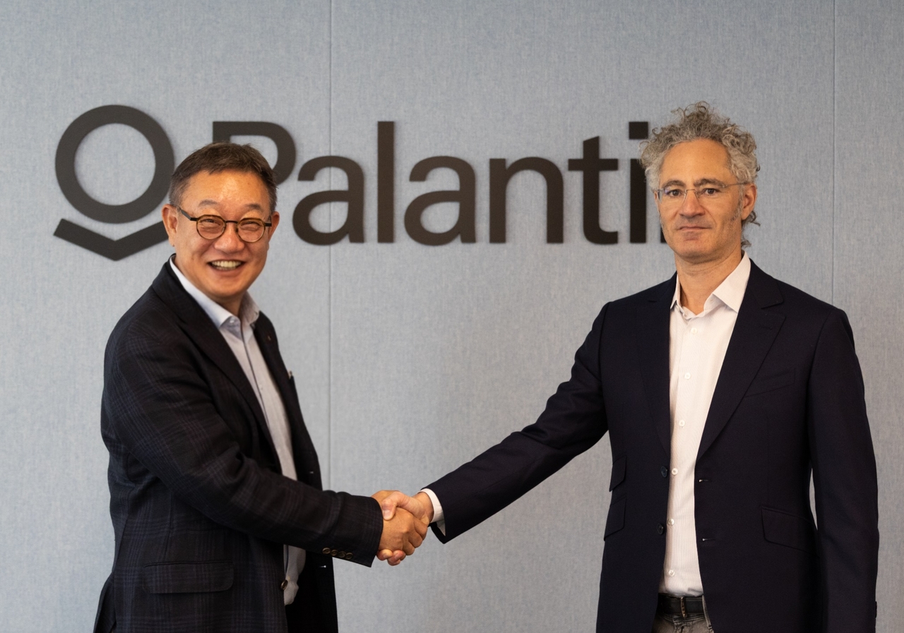 LG CNS CEO Hyun Shin-gyoon (left) and Palantir CEO Alex Karp join hands at strategic partnership signing ceremony at the US tech firm's headquarters in Miami, Florida, on Wednesday. (LG CNS)
