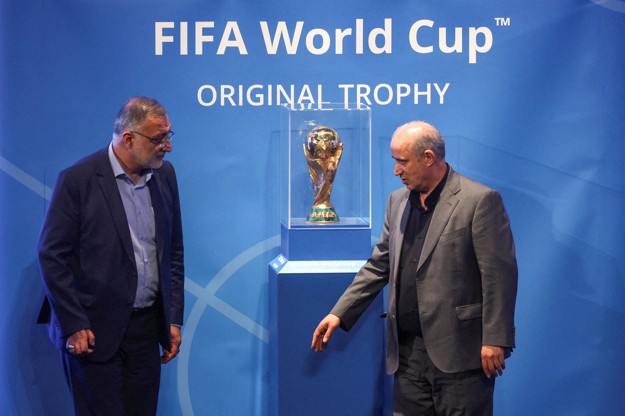 President of Iran Football Federation Mehdi Taj (right) and Mayor of Tehran Alireza Zakani stand next to the FIFA World Cup Trophy, in Tehran, Iran, Sept. 1, 2022.   (Reuters-Yonhap)