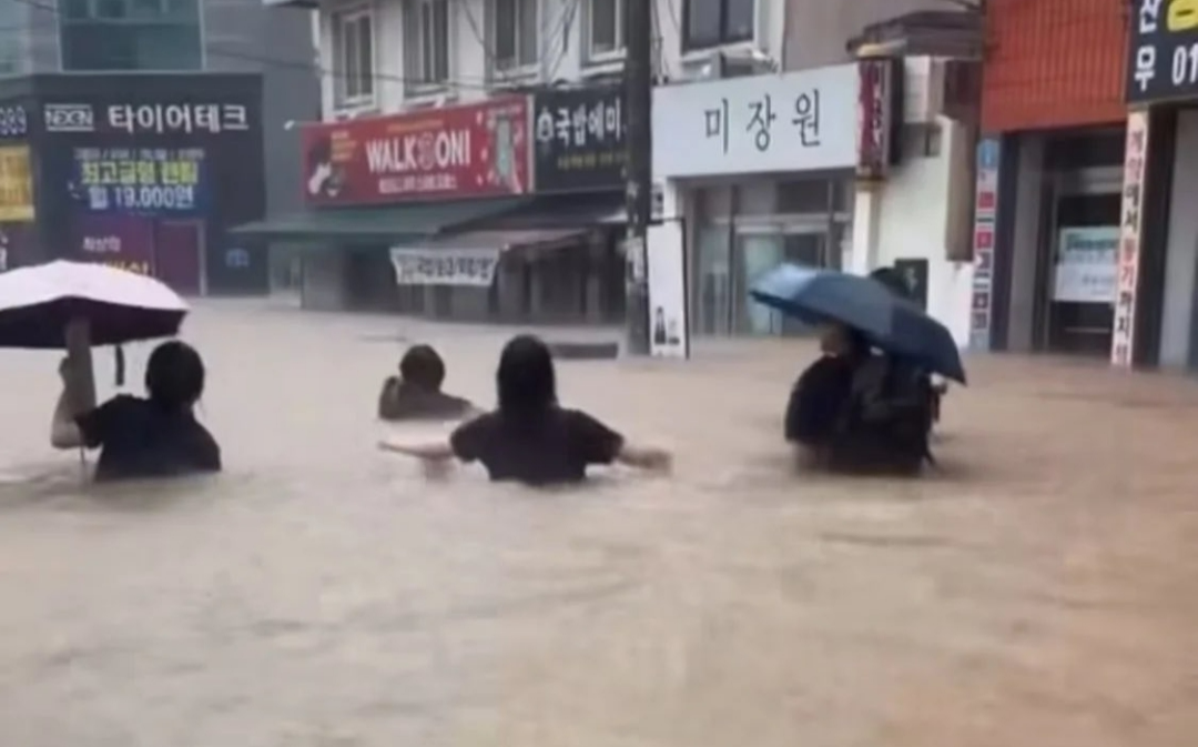 광주광역시에 국지성 집중호우 피해가 잇따른 가운데, 시민들이 허리까지 찬 빗물을 헤치고 길을 건너고 있다.[X(구 트위터) 갈무리]