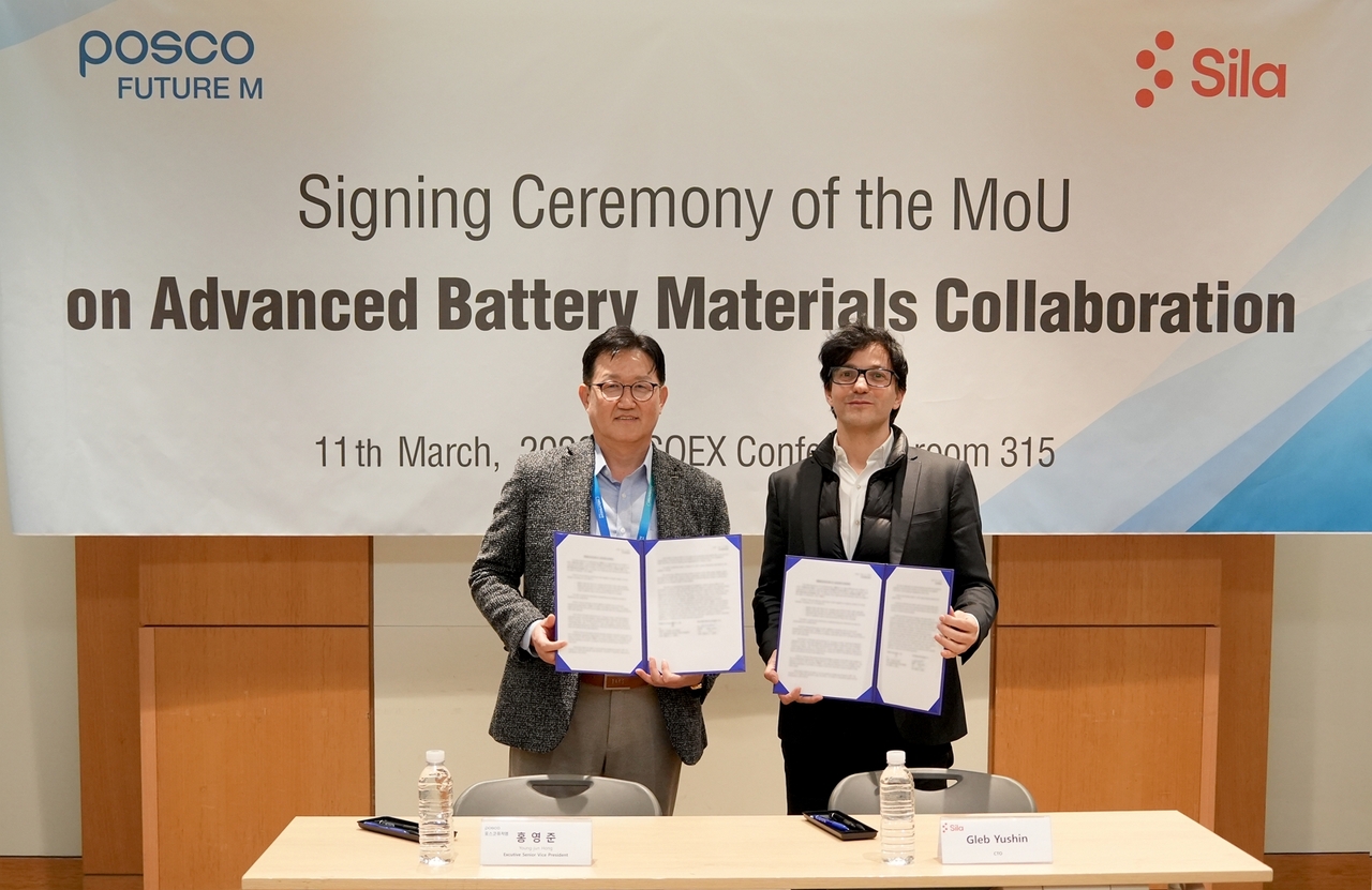 Hong Young-jun (left), head of the R&D center at Posco Future M, and Gleb Yushin, founder and chief technology officer of Sila, pose for a photo after signing a memorandum of understanding to cooperate on developing advanced battery materials at Coex, Gangnam, Seoul, Wednesday. (Posco Future M)