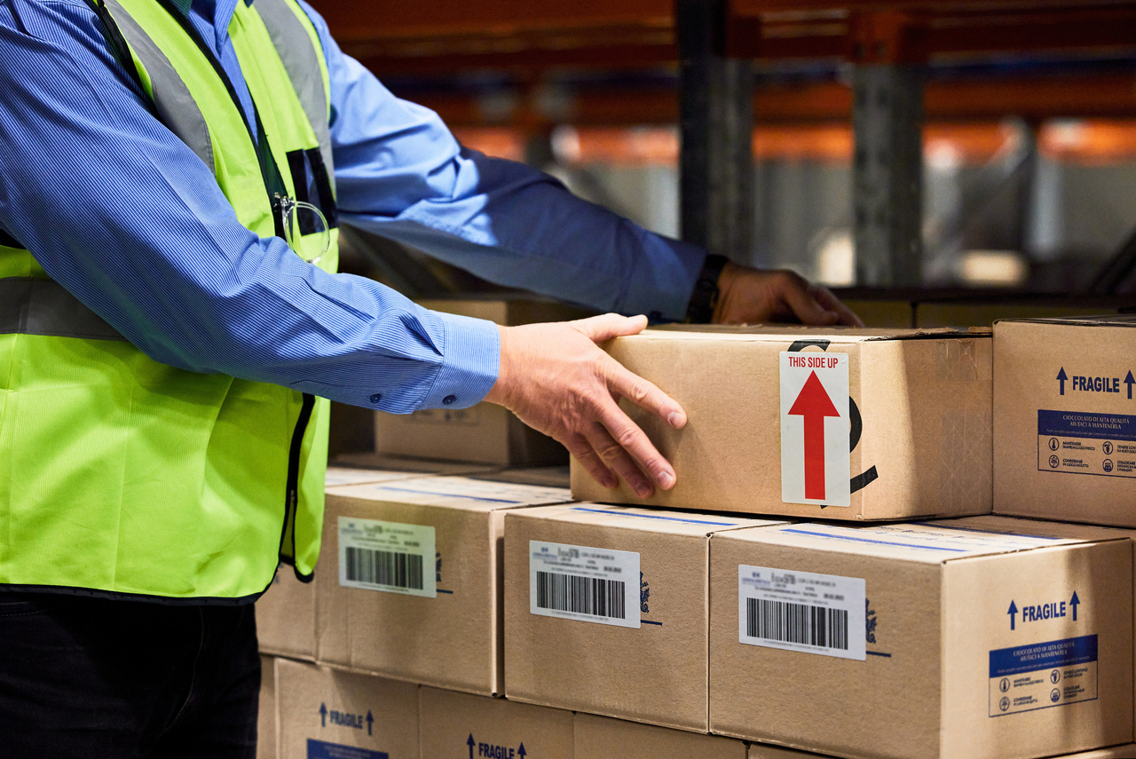 A man packs boxes in a warehouse. (123rf)
