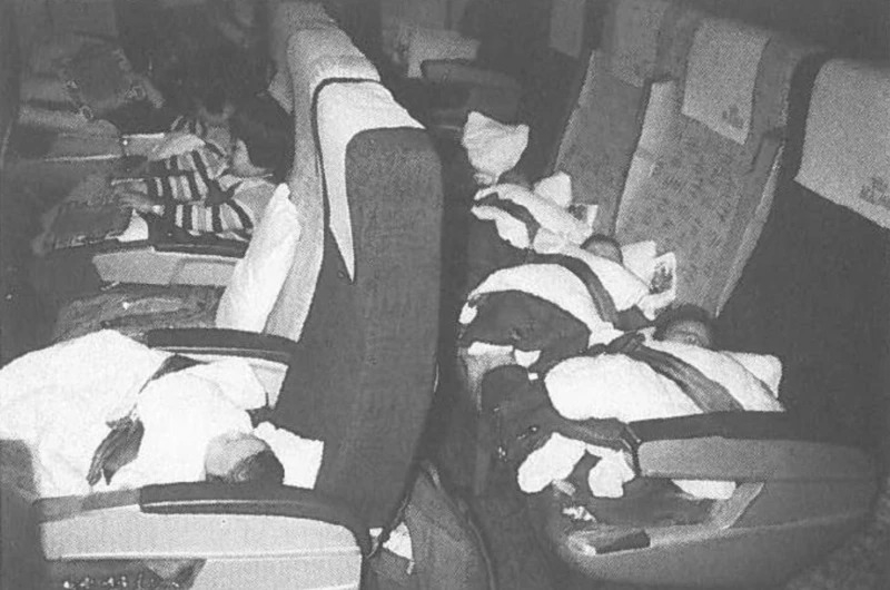 Overseas adoptees are in seats on an aircraft departing South Korea in December 1984, in this photo published in the annual report of a Danish adoption agency. (Truth and Reconciliation Commission of Korea)