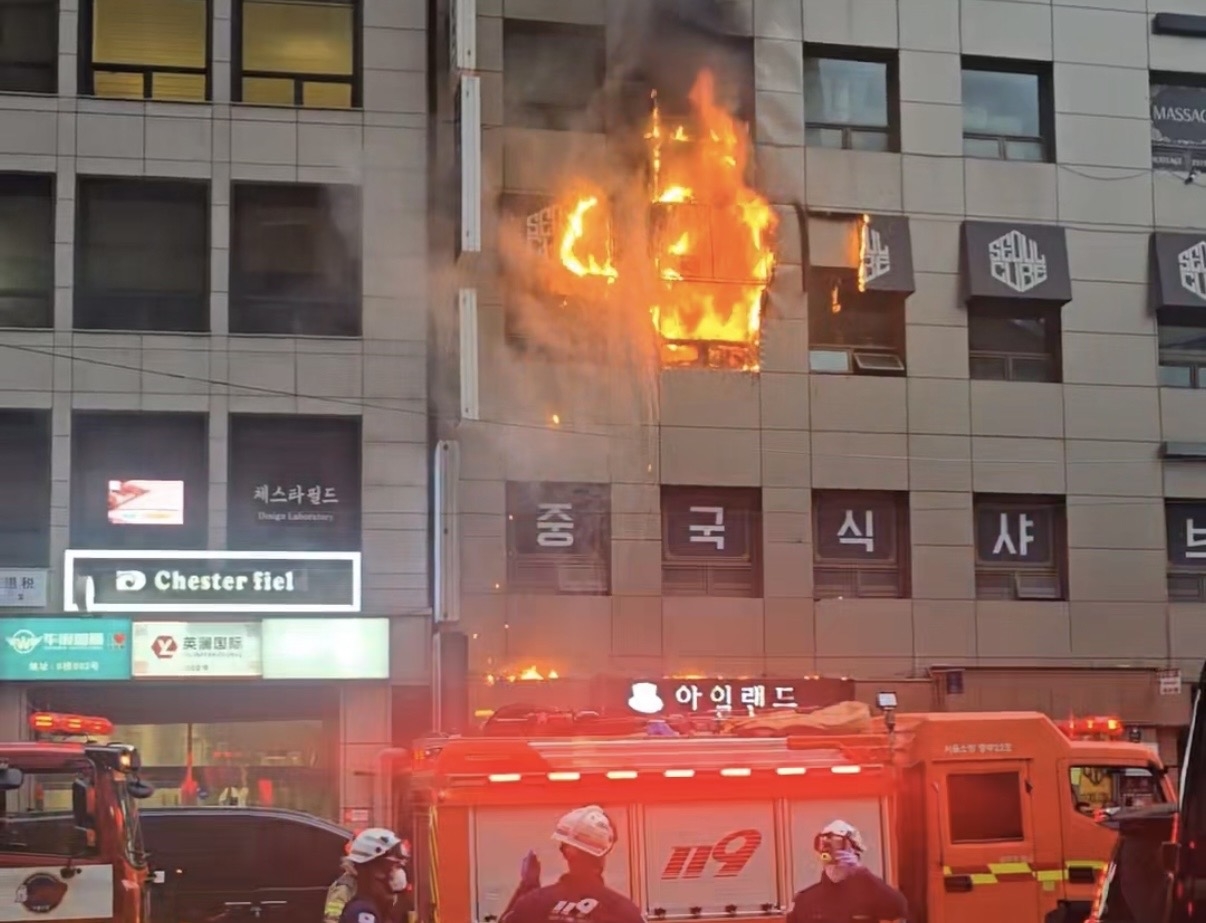 Flames are seen coming out of the windows of a building housing a capsule hotel where a fire broke out on the sixth floor in Sogong-dong, central Seoul, on Saturday. (Yonhap)
