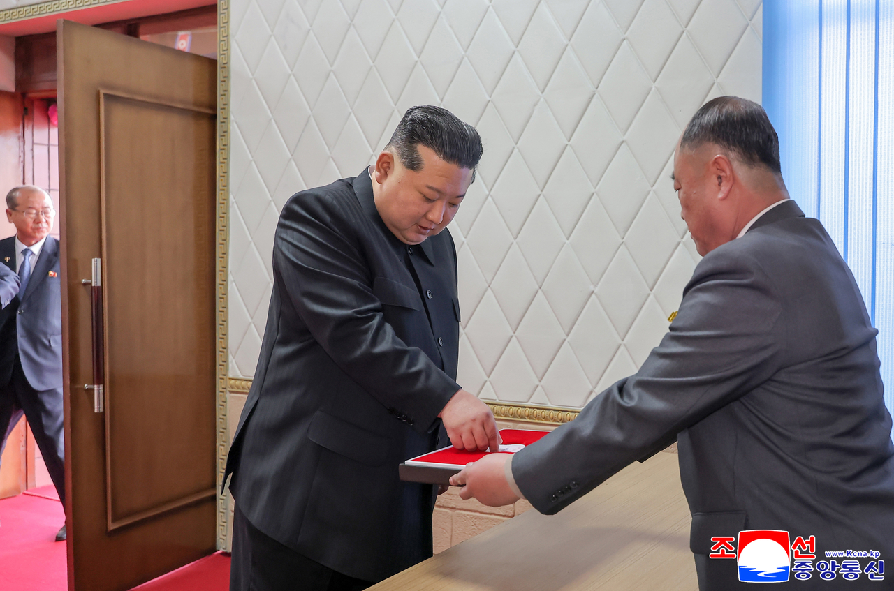 North Korean leader Kim Jong-un (left) casts a ballot at a coal mine constituency on Sunday, in elections to pick deputies to the 15th Supreme People's Assembly. (KCNA via Yonhap)