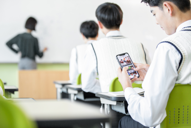 A student uses a smartphone during class. (Getty Images Bank)