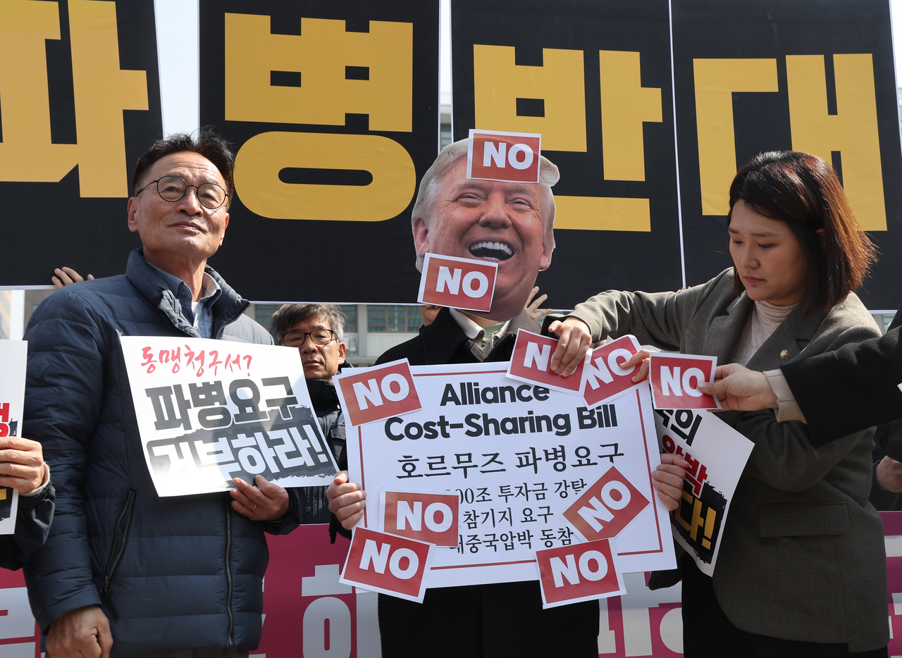 Protesters place “no” stickers on placards during a press conference condemning US President Donald Trump's request for South Korea to send troops to the Strait of Hormuz in front of the US Embassy in Seoul’s Jongno-gu on Monday. (Yonhap)