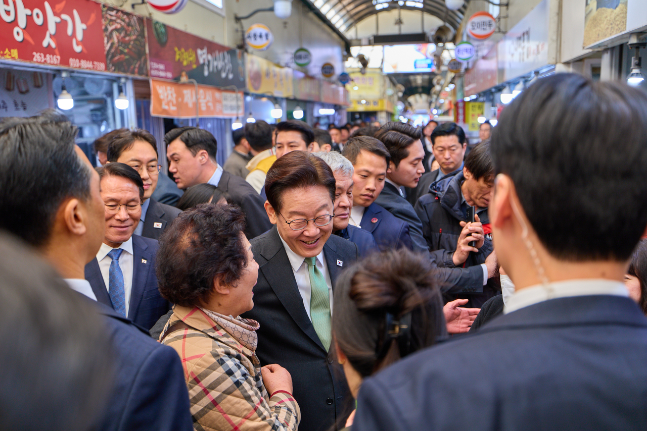 President Lee Jae Myung greets vendors and residents during a visit to a traditional market in Cheongju, North Chungcheong Province, March 13. (Cheong Wa Dae via Yonhap)