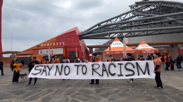 Jeju SK FC fans hold placards against racism before the team’s match with FC Seoul on Sunday at Jeju World Cup Stadium on Jeju Island. (Southernmost Instagram account)