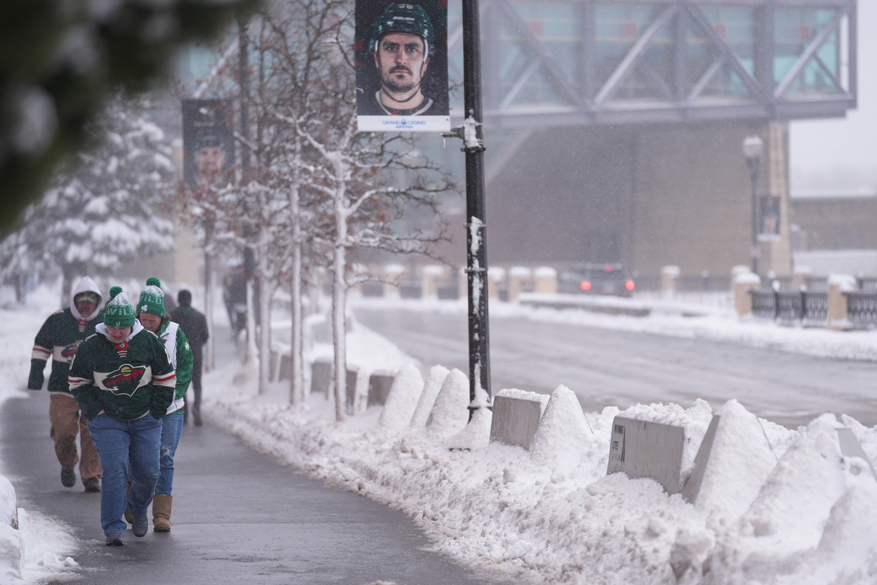 Fans walk through snowy streets before an NHL hockey game between the Minnesota Wild and Toronto Maple Leafs, Sunday. (AP-Yonhap)
