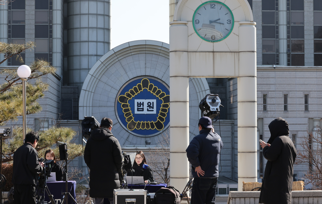 Press reports outside the Seoul Central District Court in Seoul on Feb. 18, ahead of the first verdict in former President Yoon Suk Yeol’s insurrection trial. (Yonhap)