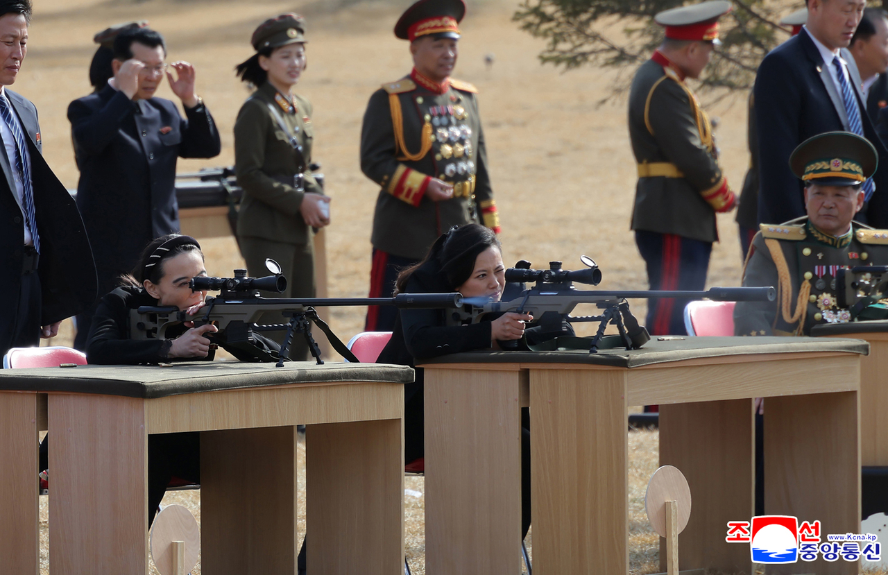 Kim Yo-jong (front left) aims a sniper rifle alongside Hyon Song-wol, a senior North Korean official and former head of the Moranbong Band, at an outdoor shooting range, in this photo released by the Korean Central News Agency on Feb. 28.  (KCNA-Yonhap)