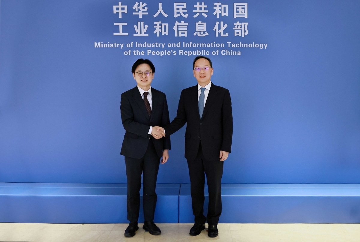 South Korean Industry Minister Kim Jung-kwan (L) and Chinese Minister of Industry and Information Technology Li Lecheng pose for a photo during their meeting in Beijing on March 18, 2026, in this photo provided by Kim's office. (PHOTO NOT FOR SALE) (Yonhap)
