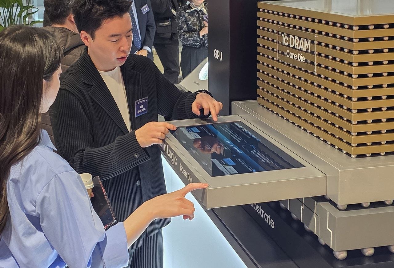 Visitors examine Samsung Electronics’ semiconductor display at the venue of its 57th annual general meeting in Suwon on Wednesday. (Samsung Electronics)