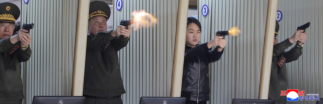 Ju-ae is seen test-firing a pistol at an indoor shooting range inside the facility alongside military officials. (KCNA-Yonhap)