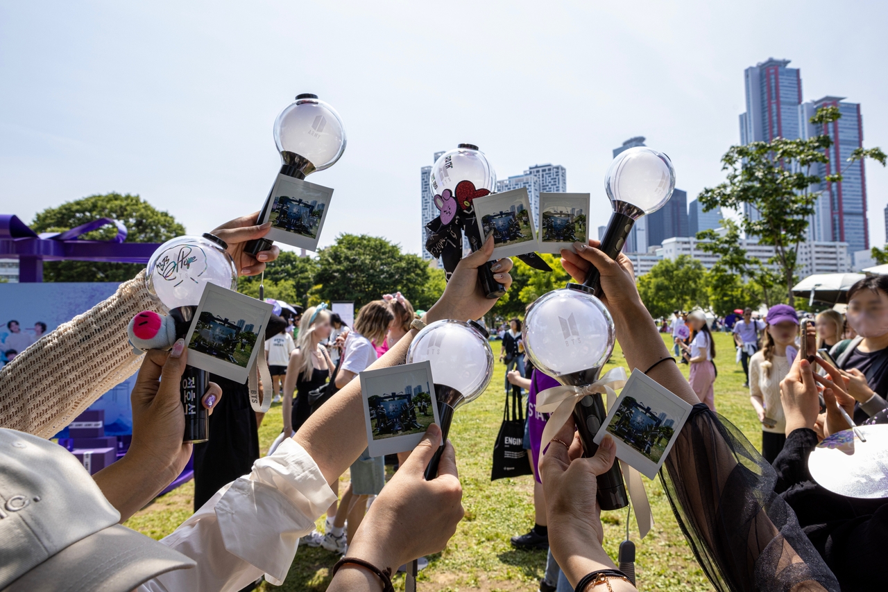 Fans photograph their official BTS'  lightsticks, also known as Army Bomb, at the BTS Festa held at Yeouido Hangang Park in western Seoul on June 17, 2023. (Big Hit Music)