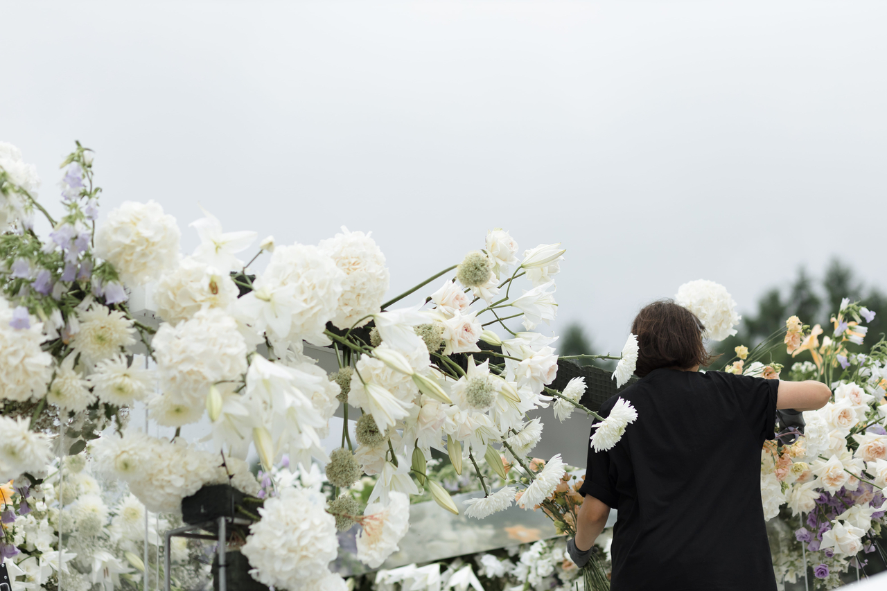 A woman mourns among white flowers. This photo is not directly related to the story. (123rf)