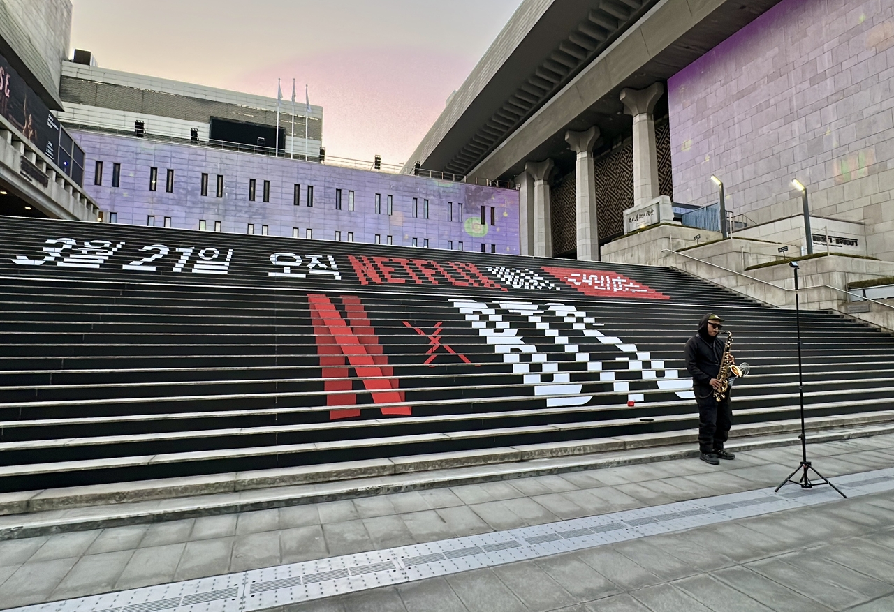 Street saxophonist plays BTS' “Butter” and Jungkook’s “Seven” at Gwanghwamun Square.