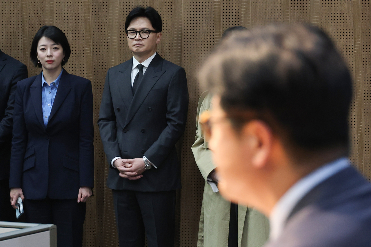 Former People Power Party leader Han Dong-hoon looks on as former Supreme Council member Kim Jong-hyuk speaks at a press conference at the National Assembly in Seoul on Friday regarding a court decision suspending the effect of a party disciplinary measure. (Yonhap)