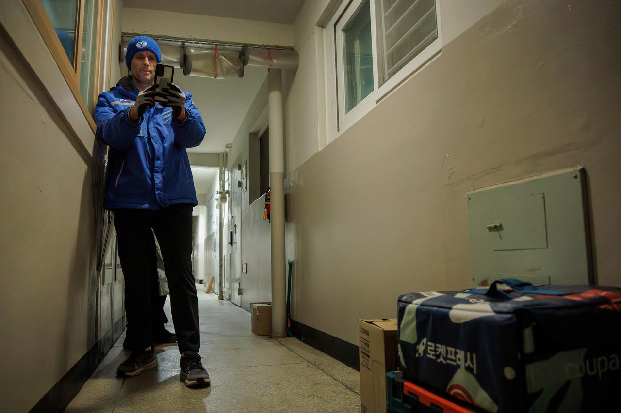 Coupang interim CEO Harold Rogers takes a photo to verify the completion of a package delivery during his overnight delivery experience in Seongnam, Gyeonggi Province, on Friday. (Coupang)
