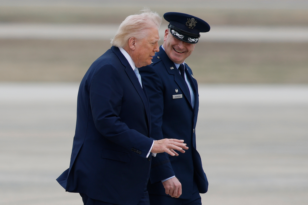 US President Donald Trump is escorted by Air Force Col. Christopher M. Robinson, commander, 89th Airlift Wing, from Marine One to Air Force One, at Joint Base Andrews, Md., Friday. (AP-Yonhap)